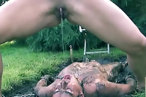Mistress pissing on sub outdoors near the mud